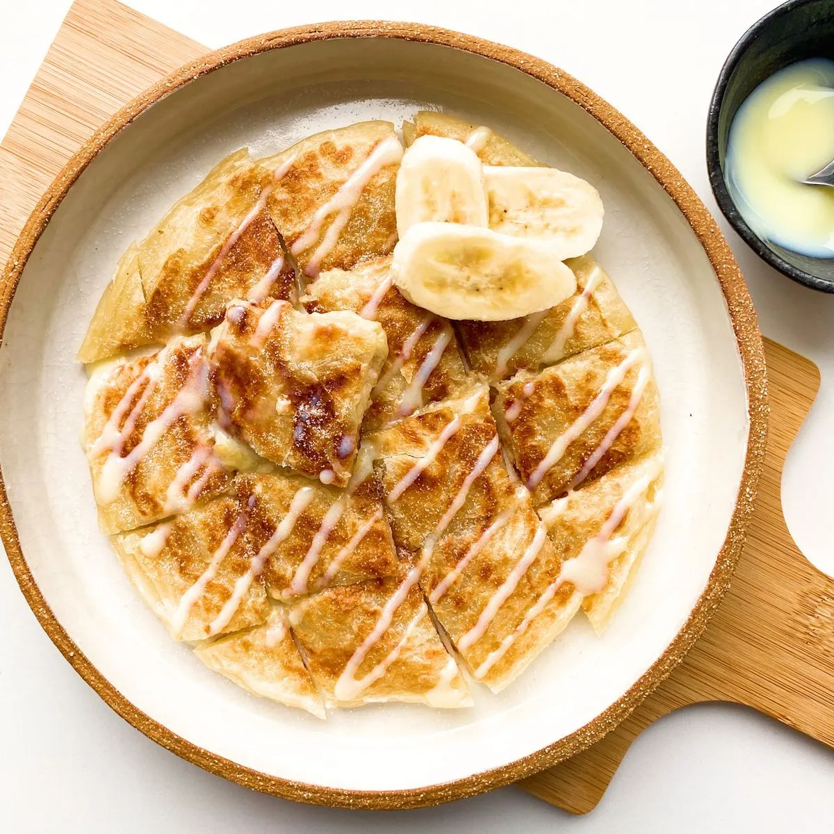 https://img.taste.com.au/aJyc7vhW/w1200-h1200-cfill-q80/taste/2024/04/banana-roti-with-condensed-milk-198057-1.jpg